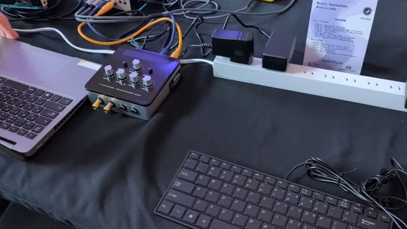 The Elk Stomp pedal on the hackathon bench beside a laptop and a keyboard.