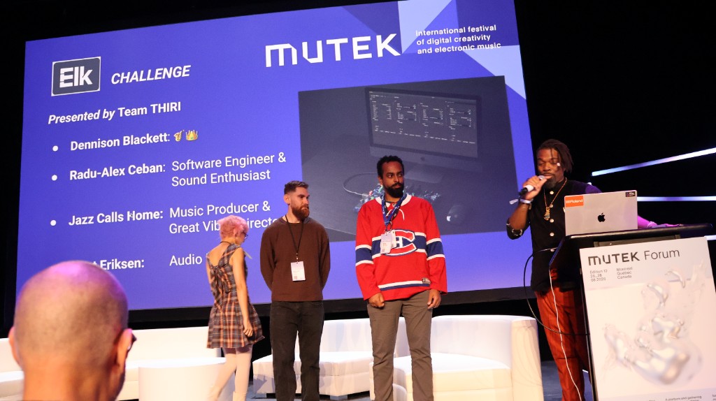 Team THIRI on stage at MUTEK Forum for the Elk Audio Challenge. Dennison Blackett at the podium in orange trousers.